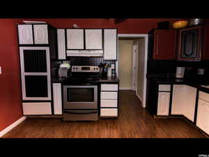 Kitchen featuring stainless steel electric stove, white cabinets, and dark hardwood / wood-style floors