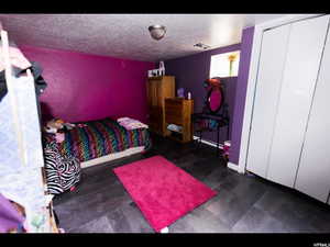 Bedroom featuring a textured ceiling and a closet