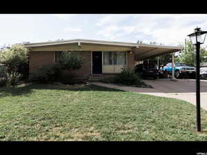 View of front of property featuring a front yard and a carport