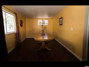 Dining area featuring dark wood-type flooring and a textured ceiling