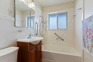 Full bathroom featuring washtub / shower combination, vanity, and toilet