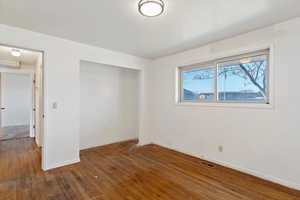 Unfurnished bedroom featuring dark wood-type flooring