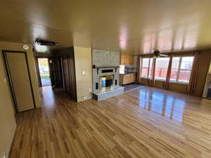 Unfurnished living room with plenty of natural light, light hardwood / wood-style floors, and ceiling fan