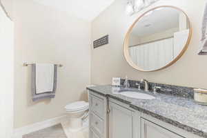 Bathroom with tile patterned floors, vanity, and toilet