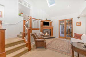 Carpeted living room with a skylight and high vaulted ceiling