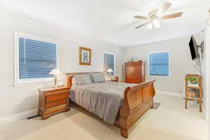 Carpeted bedroom featuring ceiling fan