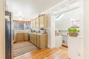 Kitchen with sink, light hardwood / wood-style floors, and appliances with stainless steel finishes