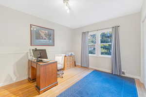 Home office with light hardwood / wood-style flooring