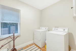 Washroom featuring light hardwood / wood-style floors and washer and clothes dryer