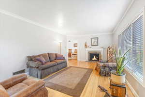 Living room with hardwood / wood-style flooring and crown molding