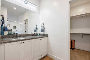 Bathroom with ceiling fan, vanity, and wood-type flooring