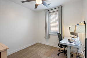 Carpeted office space featuring ceiling fan