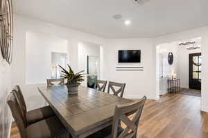 Dining room with hardwood / wood-style floors and a notable chandelier