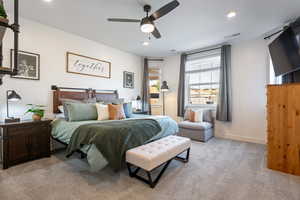 Carpeted bedroom featuring ceiling fan