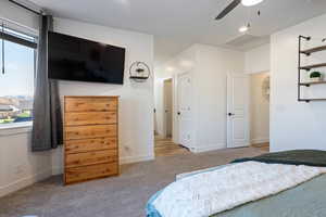 Carpeted bedroom featuring ceiling fan