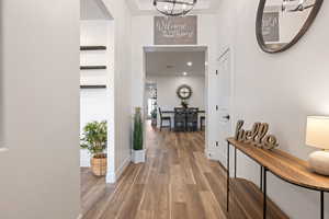 Hall featuring hardwood / wood-style flooring and a notable chandelier