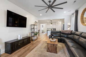 Living room with ceiling fan, sink, and light hardwood / wood-style flooring