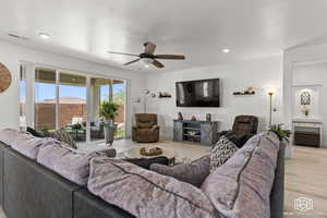 Living room with light hardwood / wood-style floors and ceiling fan