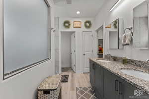 Bathroom featuring hardwood / wood-style floors, vanity, and a shower