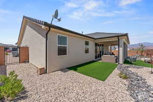 Back of house featuring a patio area, an outdoor living space, and a mountain view