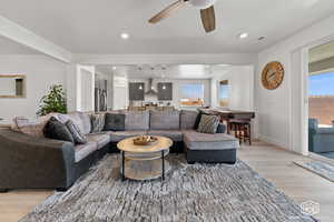 Living room with light hardwood / wood-style floors, a wealth of natural light, and ceiling fan