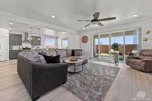 Living room featuring plenty of natural light, ceiling fan, and light wood-type flooring