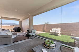 View of patio with a grill, a mountain view, and an outdoor hangout area