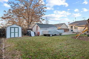 View of yard with a playground, a patio area, and a storage shed