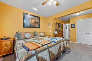 Carpeted bedroom featuring a closet and ceiling fan