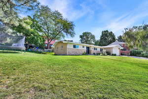 View of yard featuring a garage and a trampoline