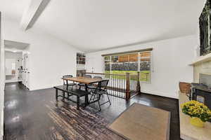 Dining room featuring vaulted ceiling with beams and dark hardwood / wood-style flooring