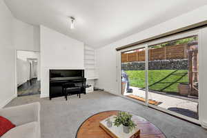 Living room featuring carpet floors and vaulted ceiling