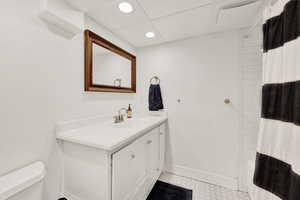 Full bathroom with vanity, shower / bath combo, and toilet