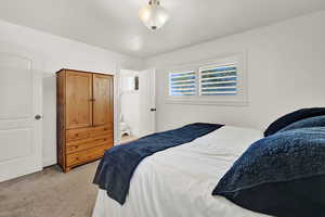 Carpeted bedroom featuring ensuite bath