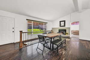 Dining area with hardwood / wood-style floors and lofted ceiling with beams