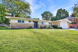 Single story home with a garage and a front yard