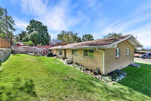 Rear view of house with cooling unit, a yard, and a swimming pool