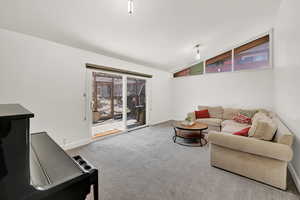 Carpeted living room featuring vaulted ceiling