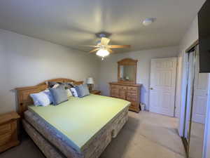 Bedroom with ceiling fan and light carpet