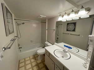 Full bathroom with tiled shower / bath combo, toilet, and vanity