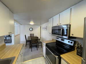 Kitchen with white cabinetry, sink, and stainless steel appliances