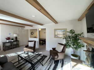 Living room featuring beam ceiling and light colored carpet