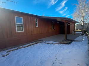 View of snowy exterior with a patio