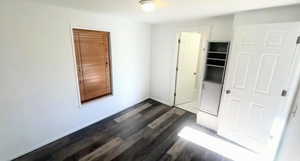 Unfurnished bedroom featuring dark wood-type flooring