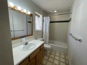 Full bathroom with vanity, toilet, and shower / tub combo with curtain