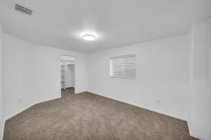 Unfurnished room featuring carpet flooring and a textured ceiling