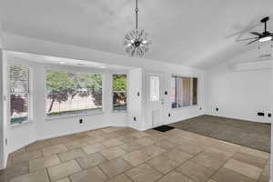 Interior space with light carpet, ceiling fan with notable chandelier, and vaulted ceiling