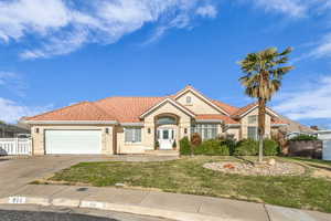 View of front of home with a front yard and a garage