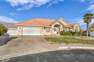 View of front facade featuring a front yard and a garage