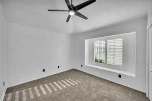 Spare room with carpet, a textured ceiling, and ceiling fan